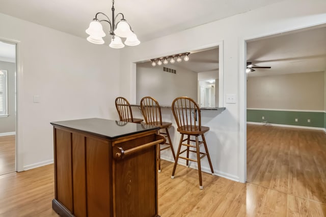 1141 Danville Rd, Lancaster, KY 40444 - dining room with light wood-type flooring, visible vents, baseboards, and ceiling fan with notable chandelier