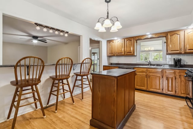 1141 Danville Rd, Lancaster, KY 40444 - kitchen with a sink, decorative light fixtures, a center island, dark countertops, and light wood-style floors