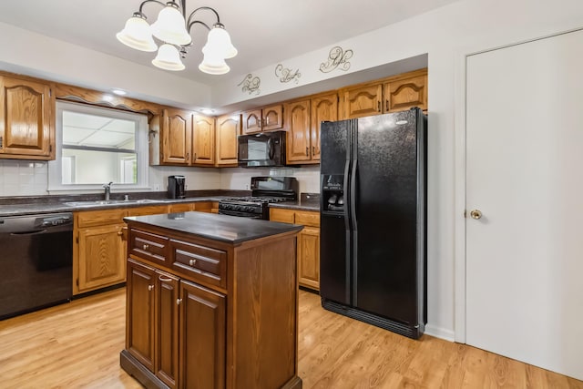1141 Danville Rd, Lancaster, KY 40444 - kitchen with an inviting chandelier, a sink, dark countertops, black appliances, and light wood-style floors
