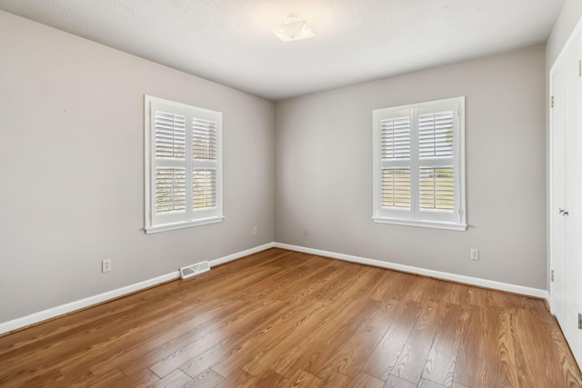 1141 Danville Rd, Lancaster, KY 40444 - unfurnished room featuring baseboards, a healthy amount of sunlight, visible vents, and wood finished floors