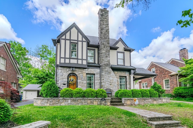 tudor house with stucco siding, stone siding, and a front lawn