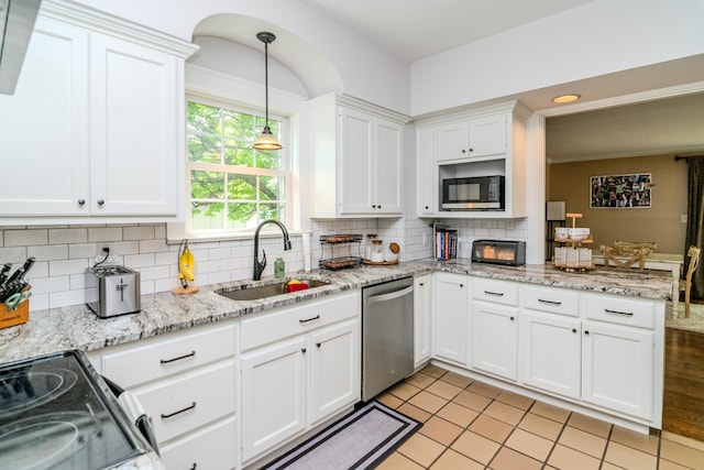 kitchen featuring black appliances, a sink, white cabinetry, decorative backsplash, and hanging light fixtures