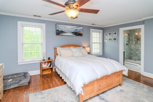 bedroom with ornamental molding, baseboards, wood finished floors, ensuite bath, and ceiling fan