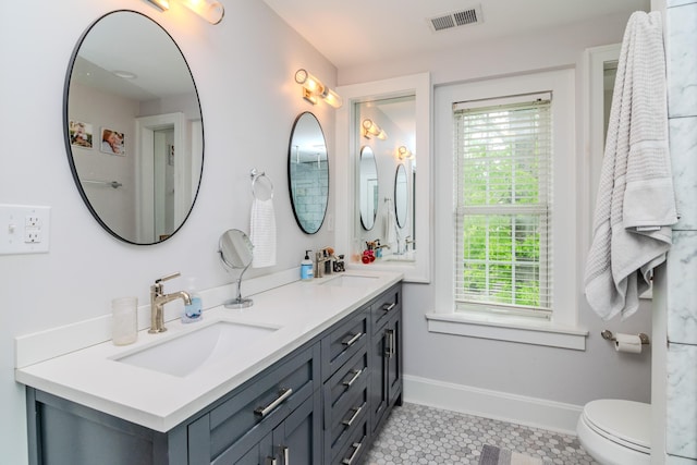 full bath with tile patterned floors, double vanity, baseboards, and toilet