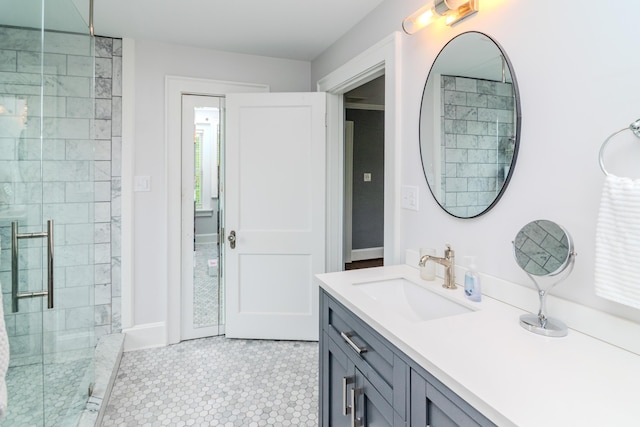 full bath with a shower stall, vanity, tile patterned floors, and baseboards