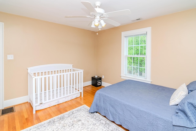 bedroom featuring wood finished floors, baseboards, and a ceiling fan