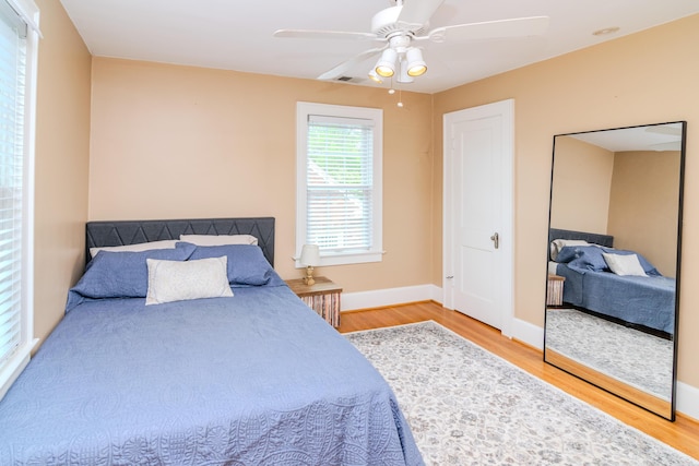 bedroom featuring wood finished floors, ceiling fan, and baseboards