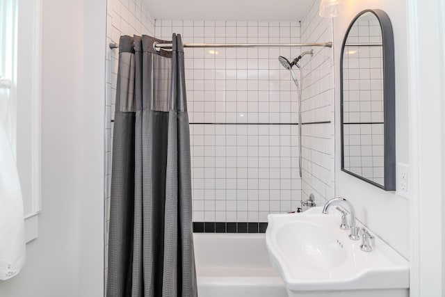 bathroom with a sink and shower / tub combo with curtain
