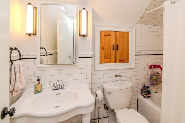 bathroom with toilet, a sink, decorative backsplash, tile walls, and shower / bathtub combination with curtain