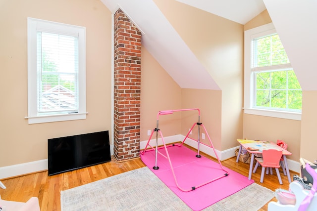 playroom featuring vaulted ceiling, wood finished floors, and baseboards