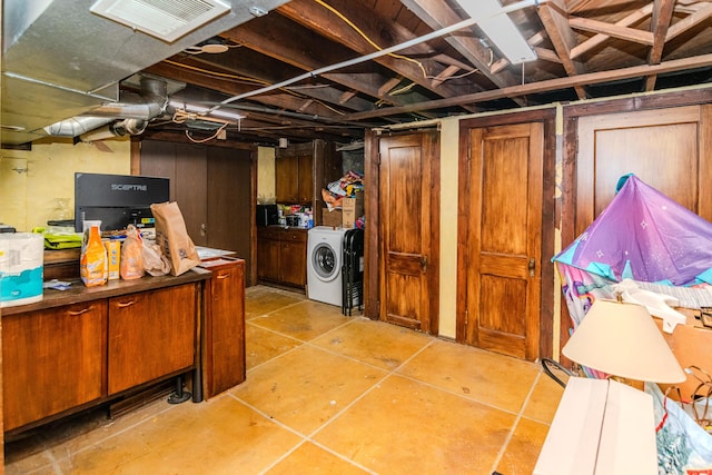 below grade area featuring separate washer and dryer and light tile patterned floors