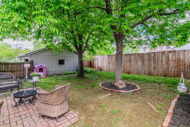 fenced backyard featuring an outdoor fire pit, a patio area, and an outbuilding