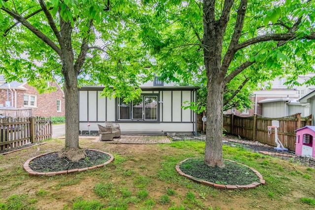 back of house with board and batten siding and a fenced backyard