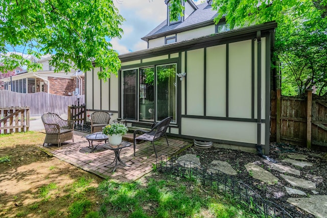 rear view of house with fence, a patio, and entry steps