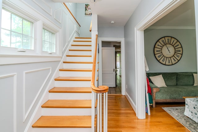 staircase featuring wood finished floors and baseboards