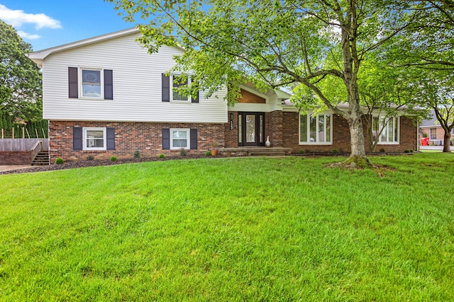 split level home with brick siding and a front yard