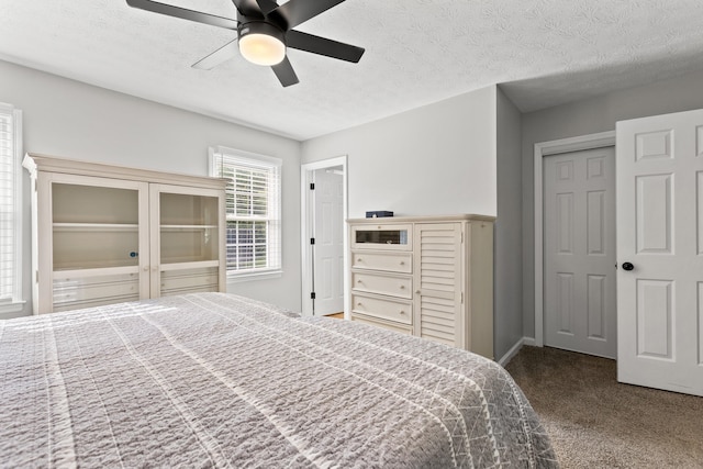 bedroom with carpet floors, ceiling fan, a textured ceiling, and baseboards