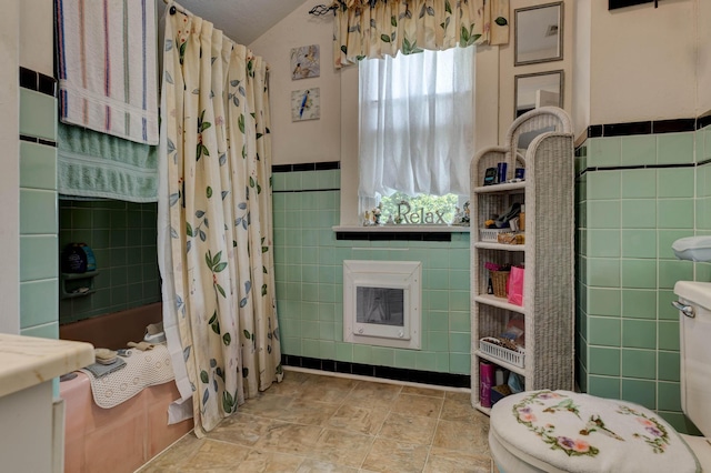 523 W High St, Mt Sterling, KY 40353 - full bathroom with tile walls, heating unit, toilet, shower / tub combo with curtain, and wainscoting
