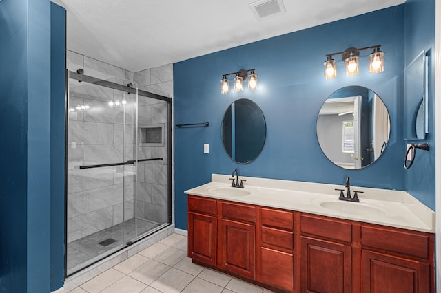 bathroom with tile patterned floors, a stall shower, and double vanity
