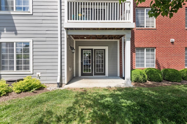 property entrance with a balcony and a yard