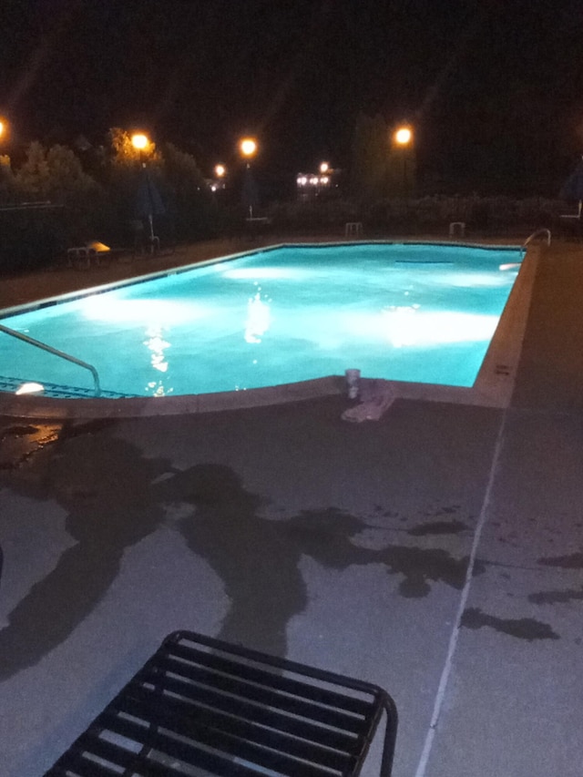 pool at twilight featuring an indoor pool and a patio area