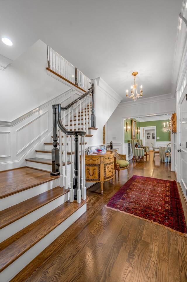 1775 Mooreland Dr, Lexington, KY 40502 - entryway featuring a decorative wall, a chandelier, stairs, wood finished floors, and ornamental molding
