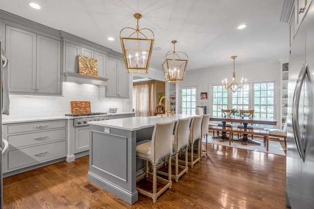 1775 Mooreland Dr, Lexington, KY 40502 - kitchen with gray cabinetry, a chandelier, appliances with stainless steel finishes, tasteful backsplash, and an island with sink