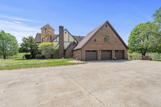 129 Adams Ln, Richmond, KY 40475 - tudor house featuring a chimney, driveway, brick siding, a garage, and a front lawn
