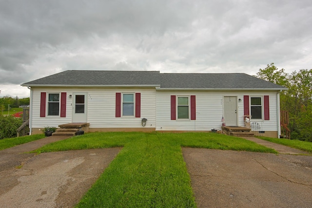 ranch-style house with a front lawn and roof with shingles