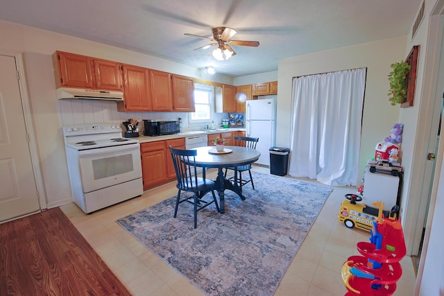 kitchen featuring a ceiling fan, visible vents, white appliances, under cabinet range hood, and light countertops