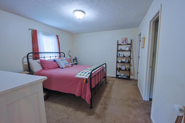 bedroom featuring light colored carpet, a textured ceiling, and baseboards