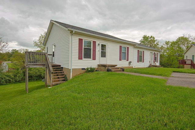 manufactured / mobile home with a front lawn, crawl space, a wooden deck, and stairs