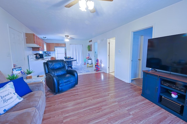 living area featuring light wood finished floors and ceiling fan
