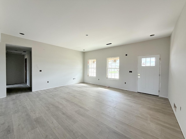 unfurnished living room with a wealth of natural light and light wood-style floors