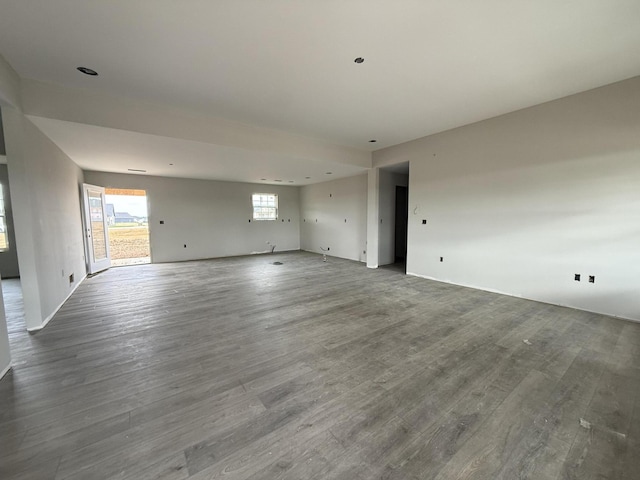 spare room with baseboards and wood finished floors