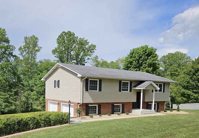 bi-level home featuring a garage, a front lawn, and brick siding