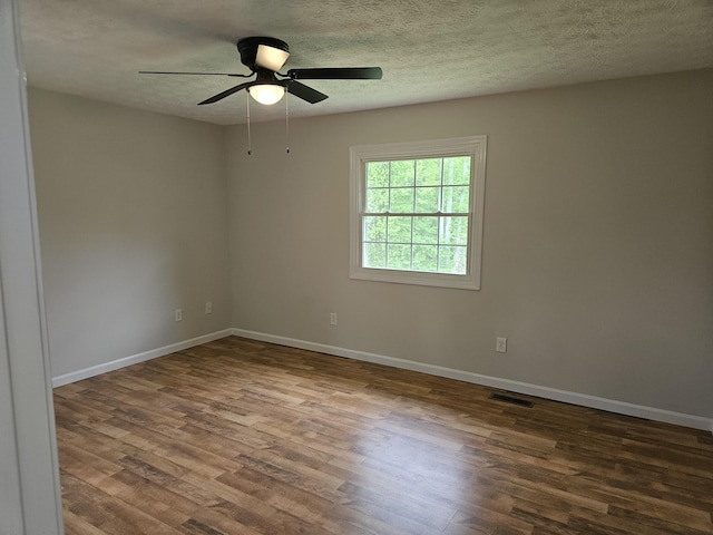spare room featuring wood finished floors, baseboards, a ceiling fan, and a textured ceiling