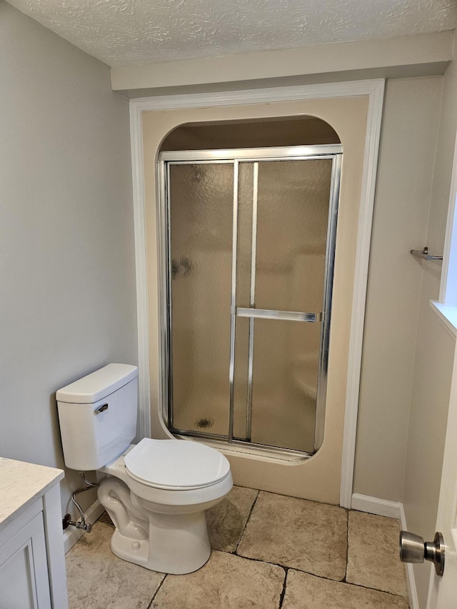full bathroom with a stall shower, toilet, vanity, and tile patterned floors