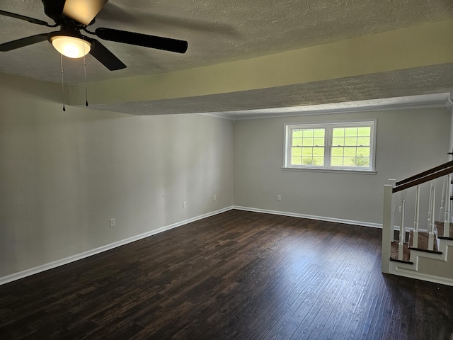 spare room with dark wood-style flooring, stairway, ceiling fan, a textured ceiling, and baseboards