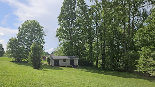 view of green lawn with an outdoor structure