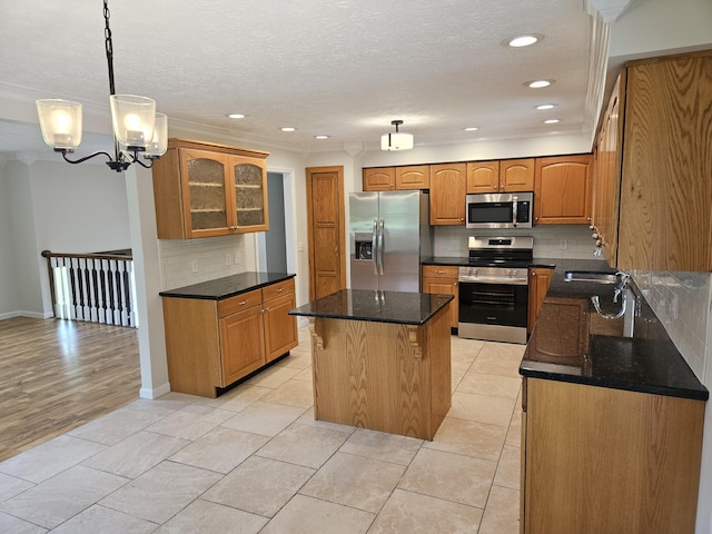 kitchen with stainless steel appliances, a center island, decorative backsplash, recessed lighting, and a chandelier