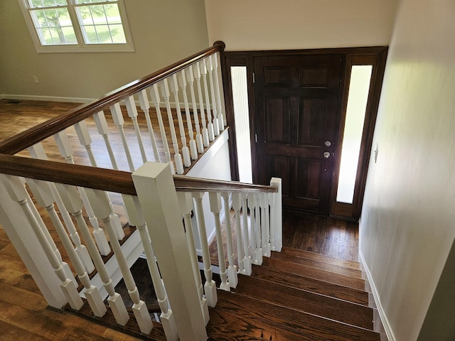 stairway featuring hardwood / wood-style flooring and baseboards
