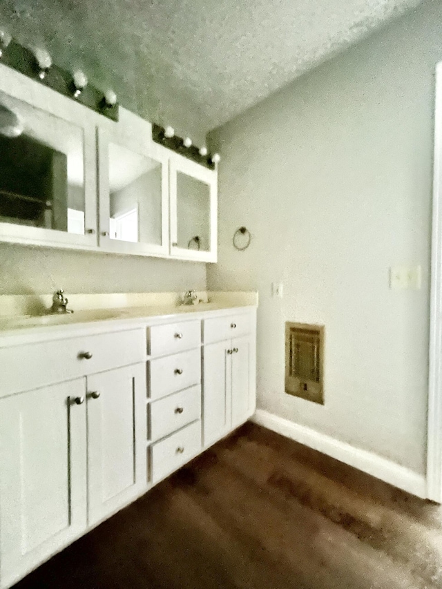 500 Meadowlark Dr, Somerset, KY 42503 - bathroom with double vanity, wood finished floors, a textured ceiling, visible vents, and baseboards