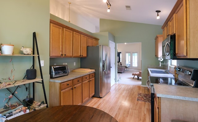2204 Market Garden Ln, Lexington, KY 40509 - kitchen featuring stainless steel appliances, vaulted ceiling, light wood-style flooring, light countertops, and brown cabinets