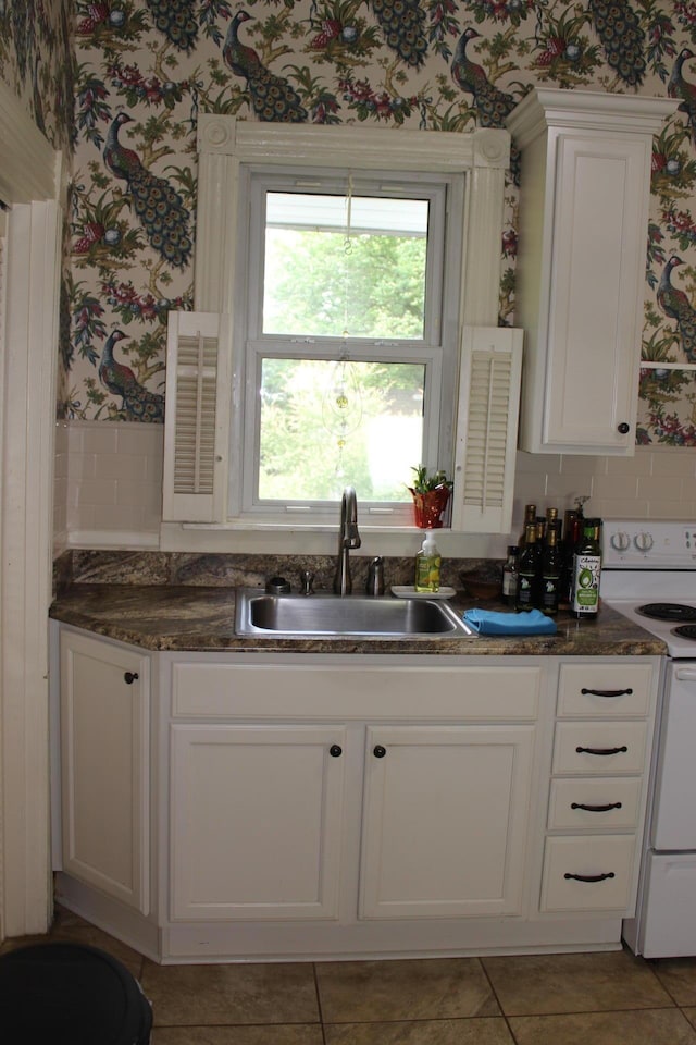 121 Smith Ballard St, Richmond, KY 40475 - kitchen with a sink, white electric stove, wallpapered walls, white cabinets, and light tile patterned floors