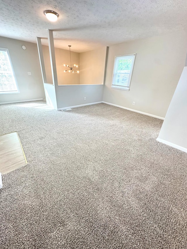 564 Ohio St, Lexington, KY 40508 - carpeted empty room with a textured ceiling, a chandelier, and baseboards