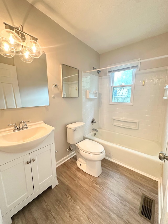 564 Ohio St, Lexington, KY 40508 - full bath with wood finished floors, toilet, bathtub / shower combination, baseboards, and vanity