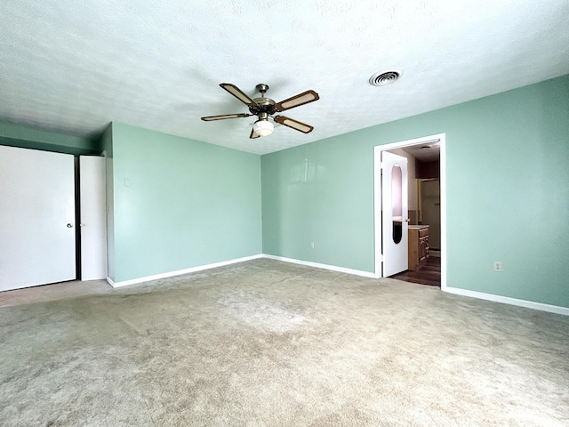 unfurnished bedroom with ensuite bath, visible vents, baseboards, and carpet floors