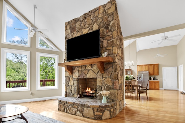 1117 Cliffs Edge Rd, East Bernstadt, KY 40729 - living area featuring high vaulted ceiling, ceiling fan, a stone fireplace, light wood-style floors, and baseboards