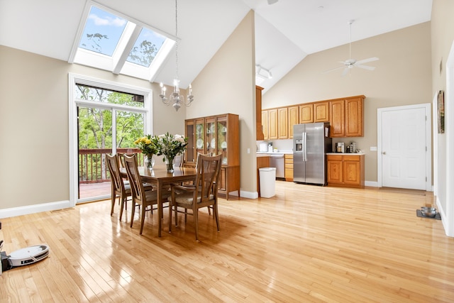 1117 Cliffs Edge Rd, East Bernstadt, KY 40729 - dining space with a skylight, high vaulted ceiling, light wood-style floors, a chandelier, and baseboards